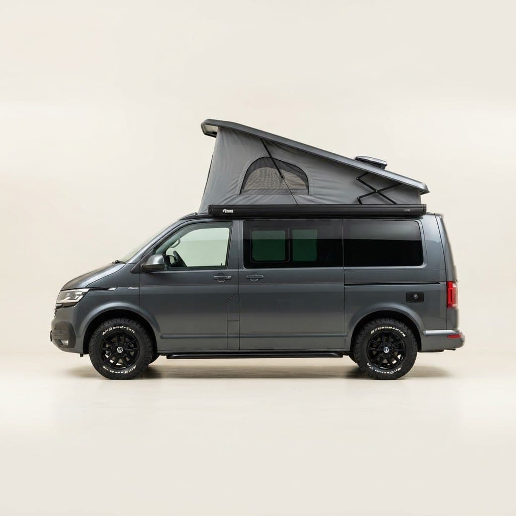 Side profile of a dark grey VW Transporter campervan with an elevated fabric pop-top roof raised open